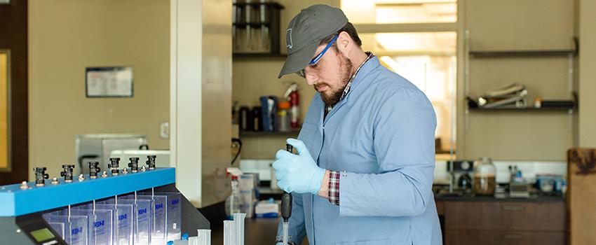 Male student using dropper in lab.